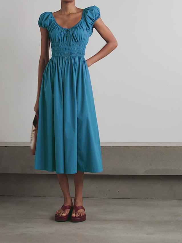 Experience the charm of the Californian coast with the Quinn Poplin Midi Dress by DÔEN. Crafted from crisp cotton-poplin, this dress features a shirred bodice that flatters your silhouette and elegant puffed sleeves for a touch of romantic allure. Its prairie-inspired design offers effortless style, making it perfect for both casual outings and special occasions. Embrace timeless femininity and comfort in one versatile piece.